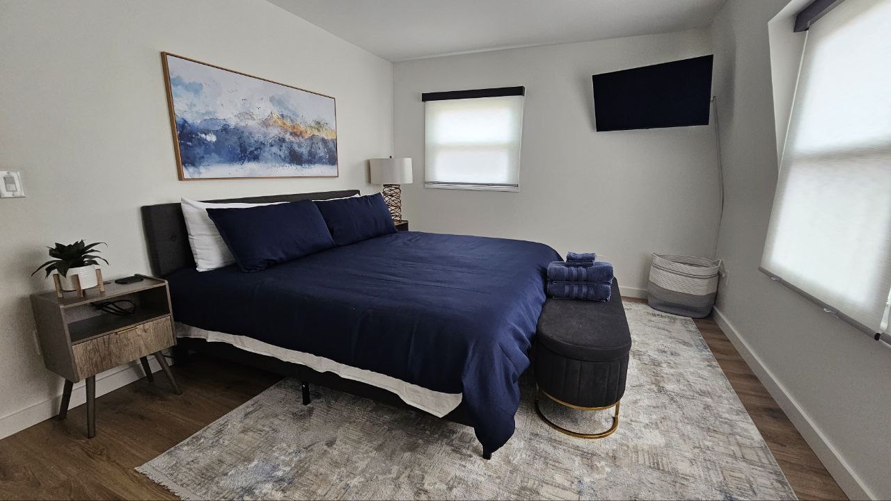 Bigfoot's Hideaway king bedroom with navy bedding and mountain art